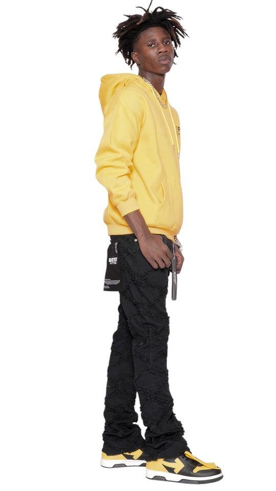 Person wearing a yellow hoodie and black pants on a white background