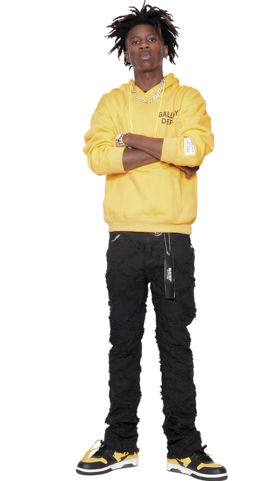 Person wearing a yellow hoodie and black pants on a white background