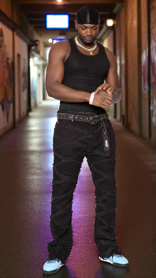 Man in black tank top and pants standing in a hallway with colorful lighting