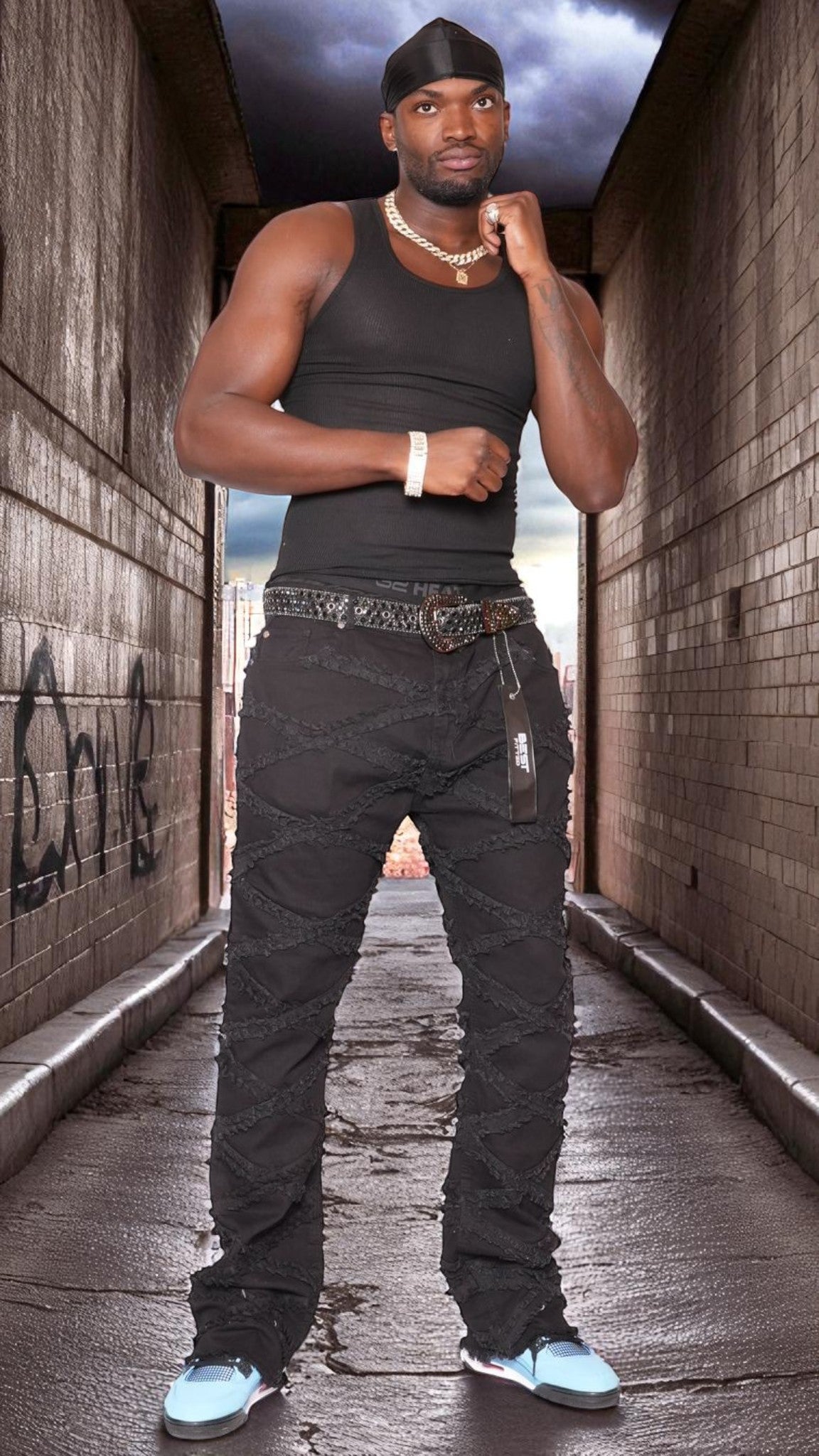 Man in black tank top and pants standing in a narrow alleyway.