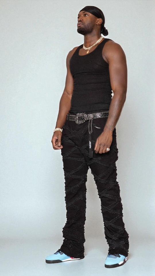 Man wearing a black tank top and black pants with a white background