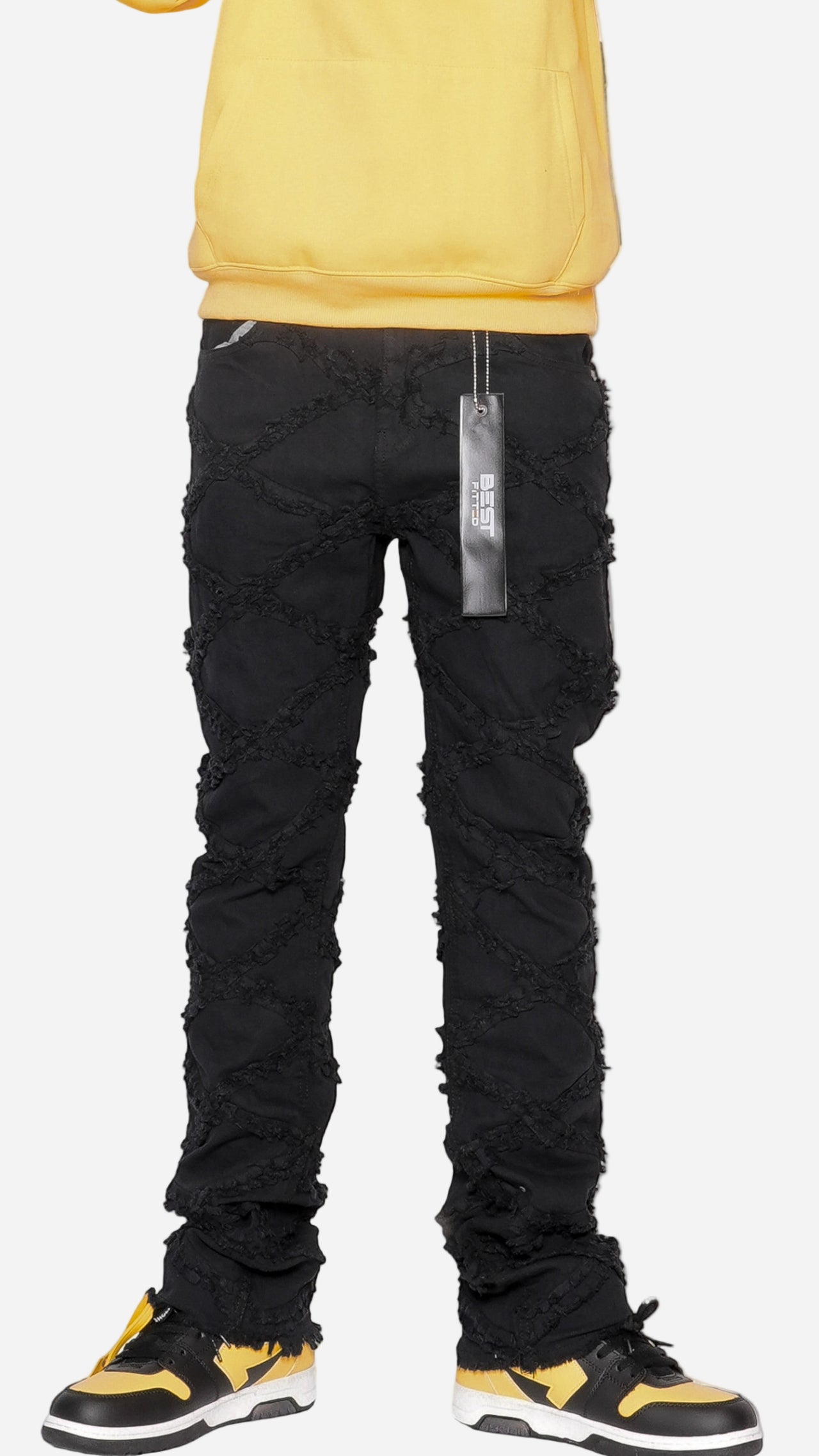Black distressed jeans with a yellow top on a white background