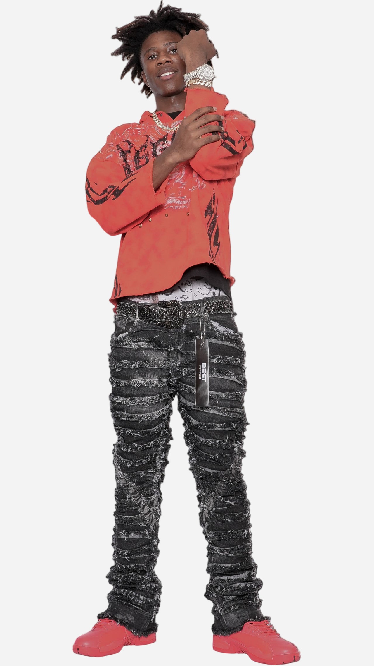 Person wearing a red sweatshirt and black pants with white patterns on a gray background