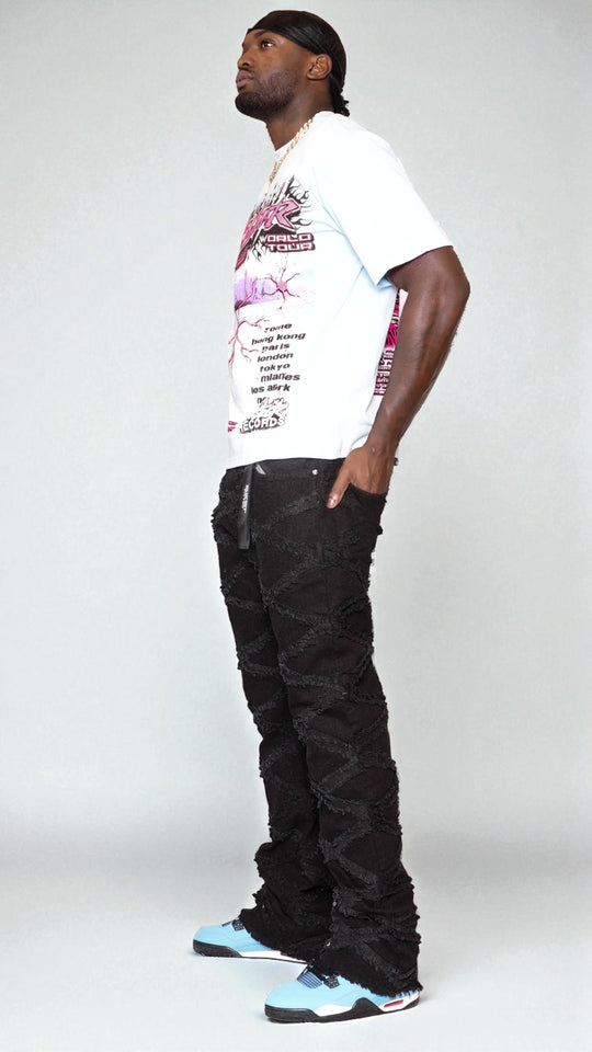 Man wearing a white t-shirt with graphic design, black pants, and colorful sneakers on a white background