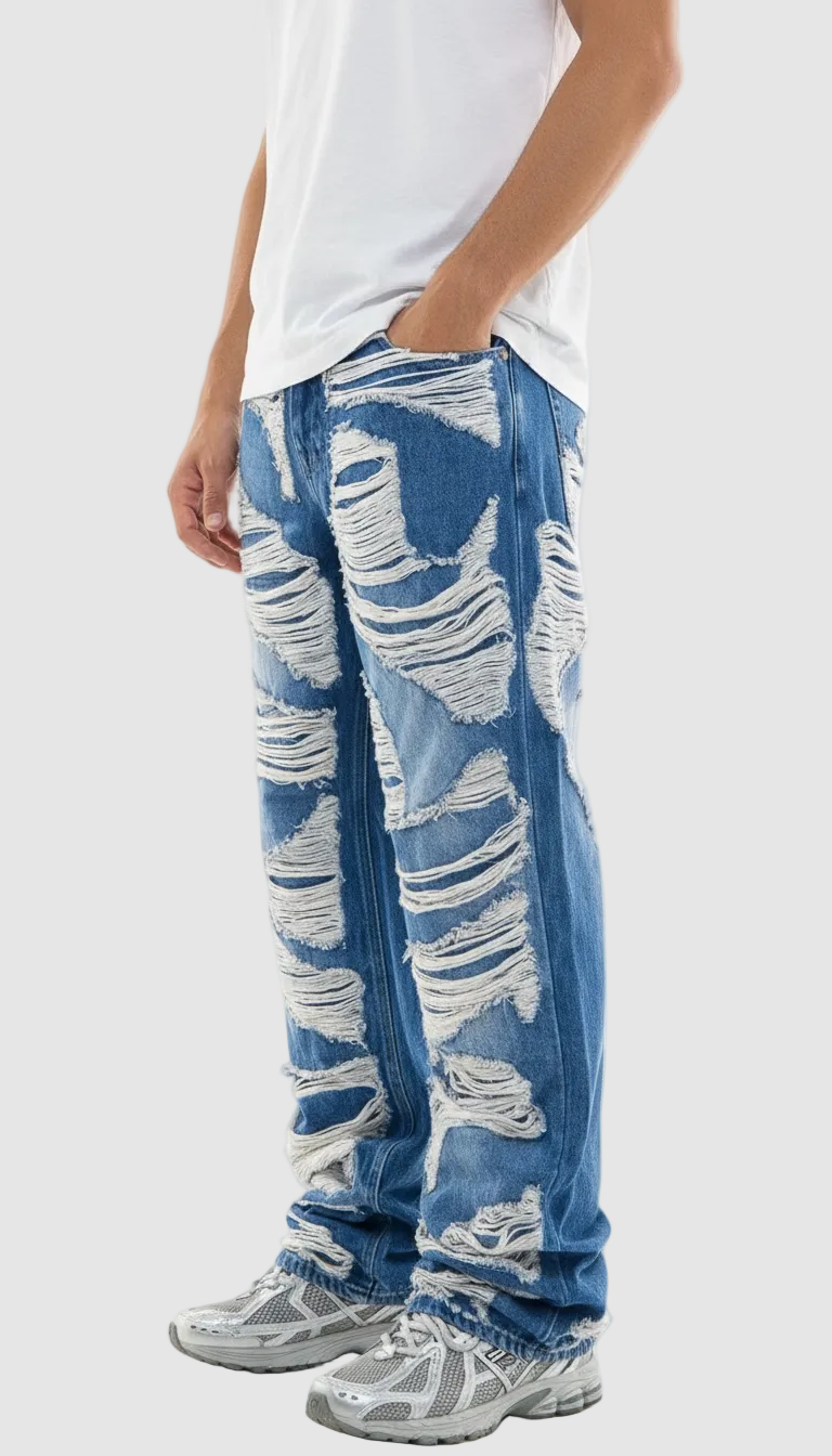 Person wearing blue distressed jeans on a white background