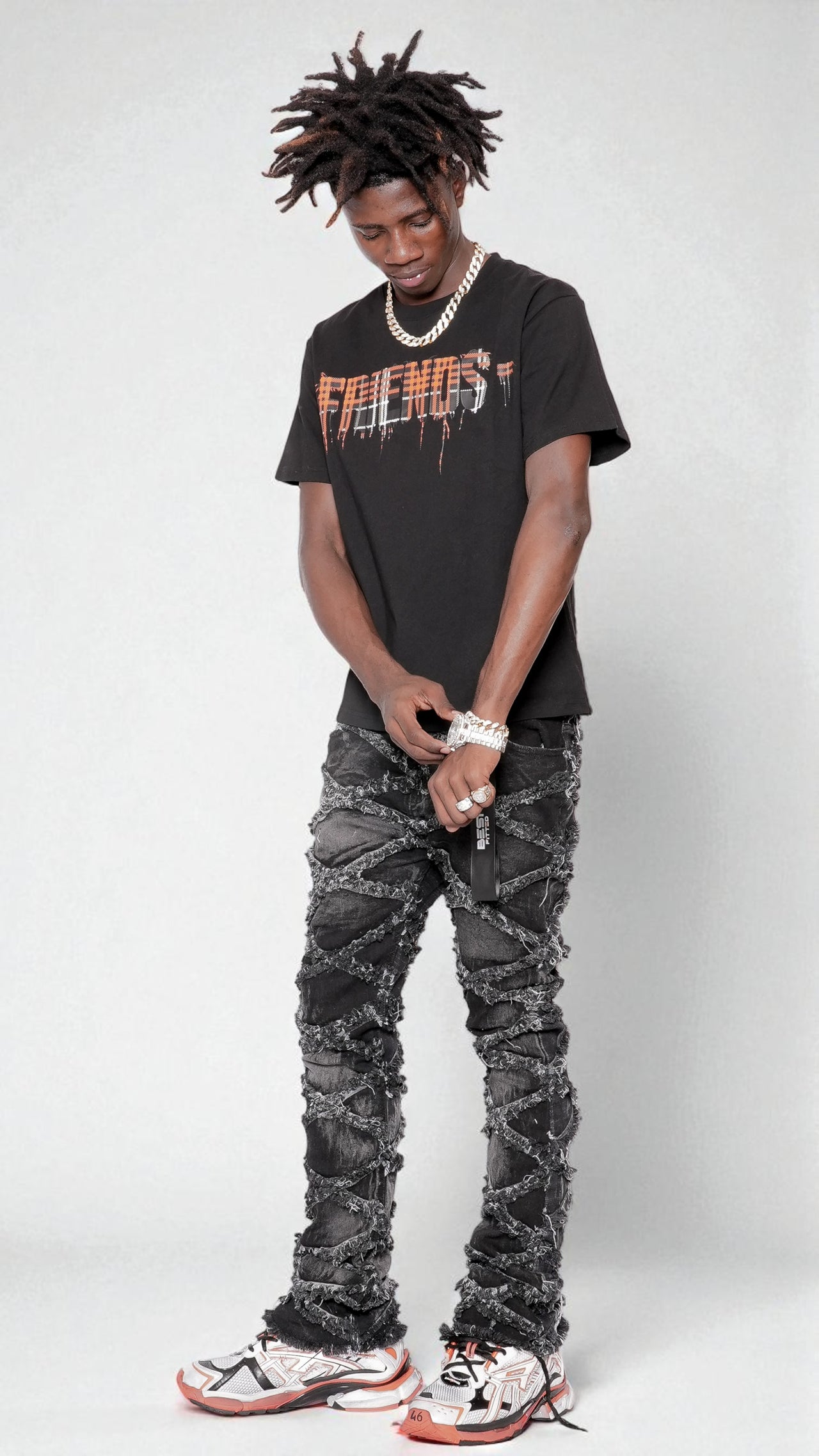 Person wearing a black t-shirt with text and dark jeans on a white background