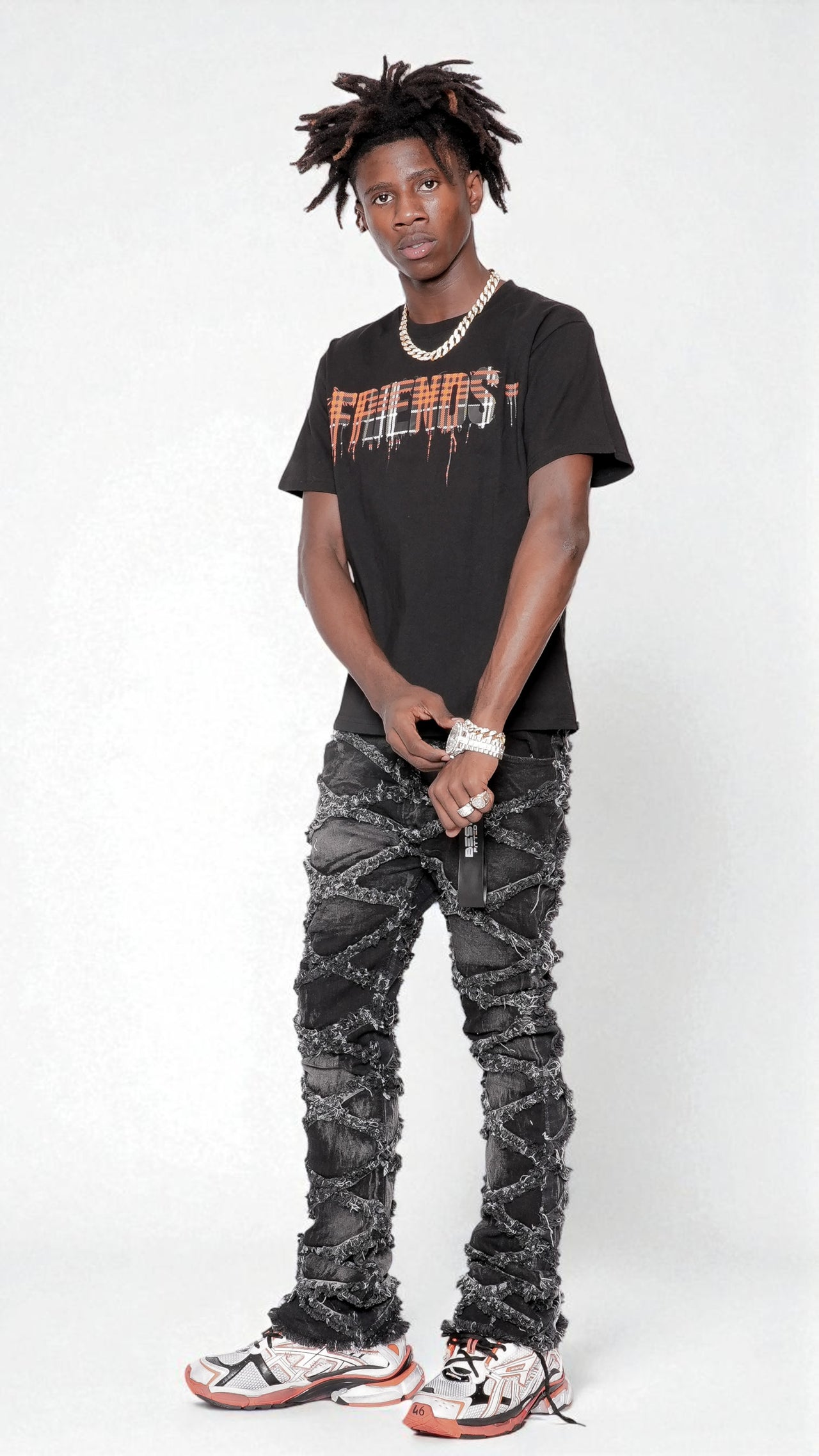 Person wearing a black 'FRIENDS' t-shirt and gray jeans on a white background