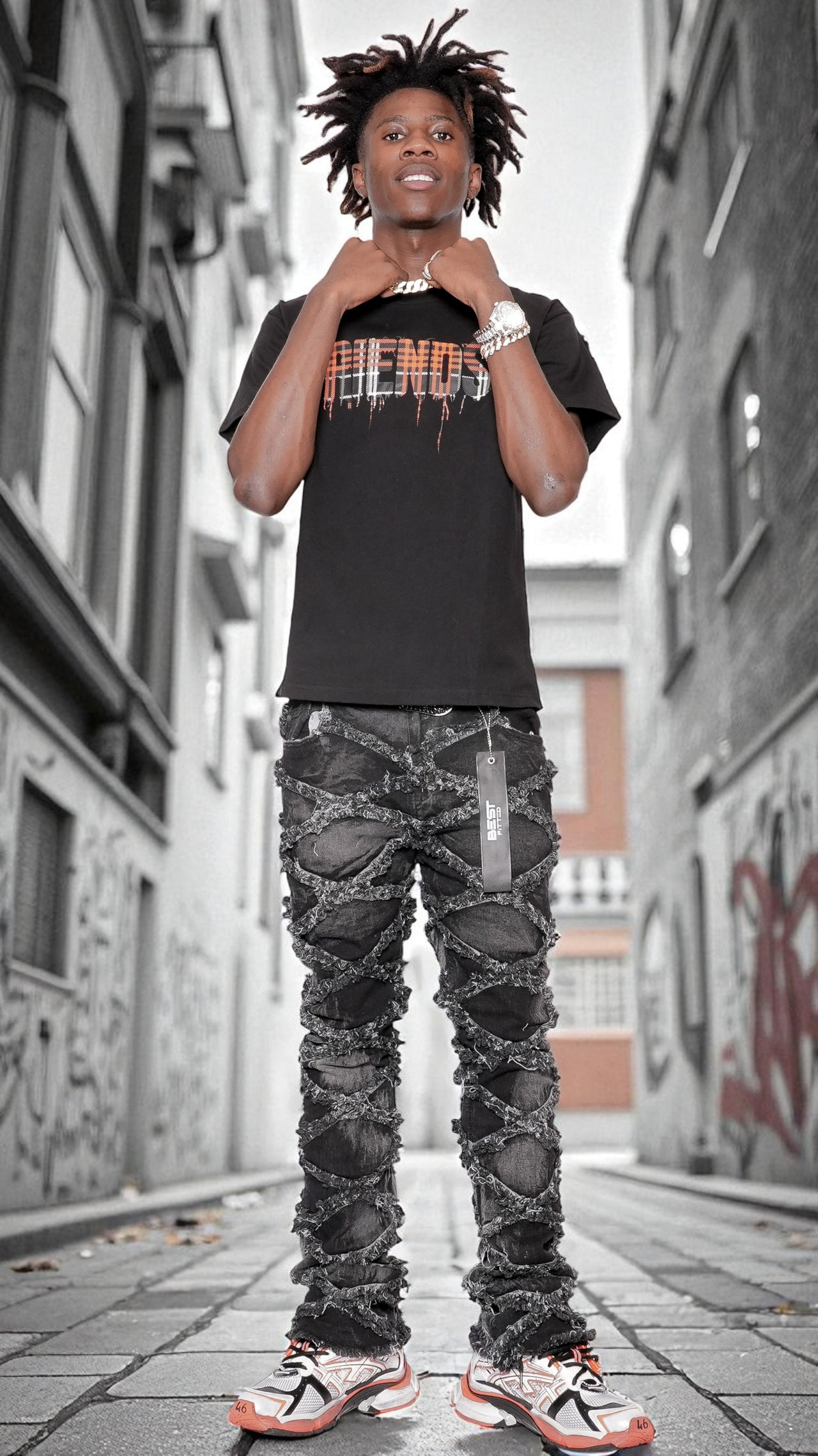 Person wearing a black t-shirt with colorful text and camouflage pants standing on a street.