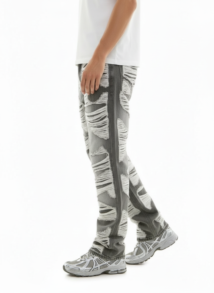 Person wearing gray and white patterned pants with a plain background