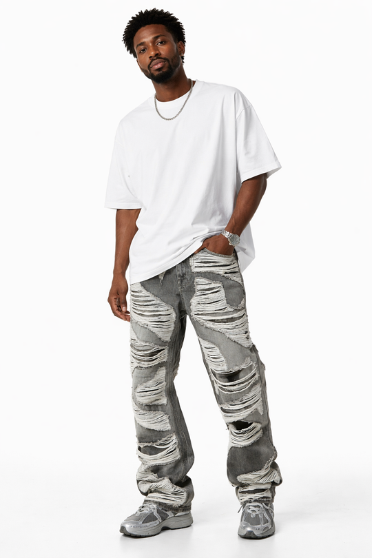 Man wearing a white oversized t-shirt and camouflage pants on a white background