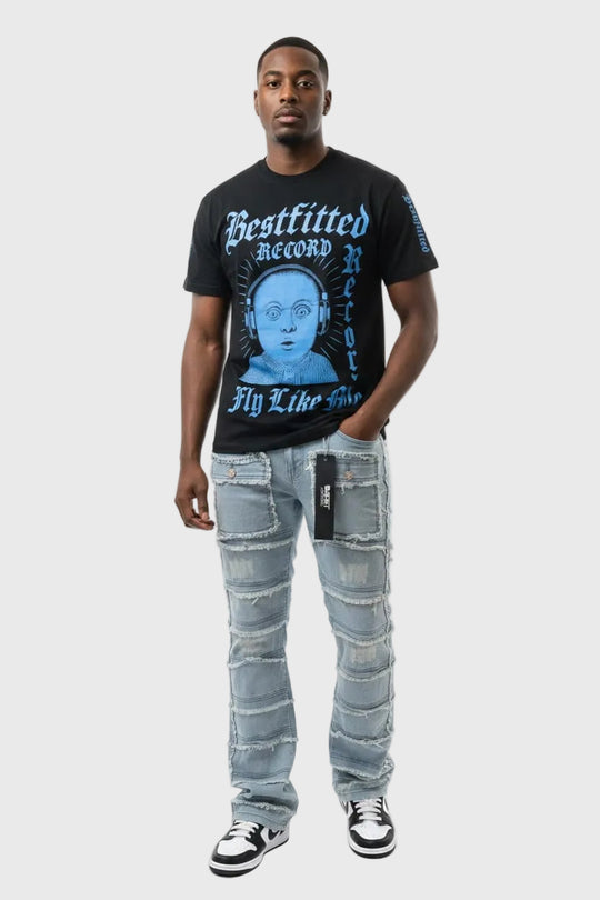 Man wearing a black t-shirt with graphic design and light blue jeans on a white background