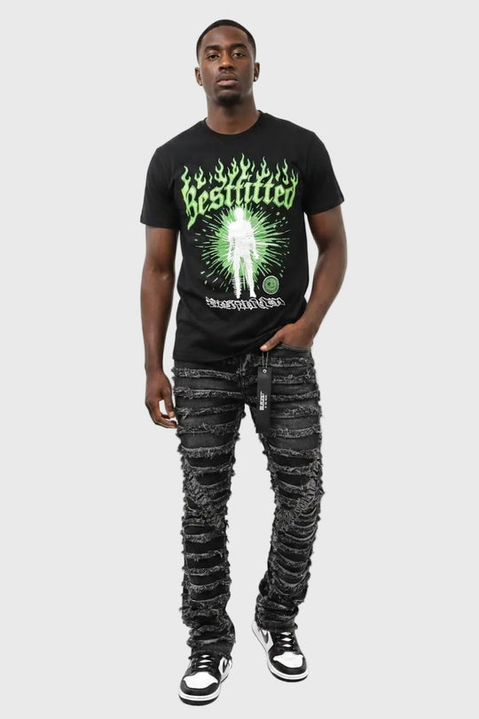Man wearing a black t-shirt with a graphic design and distressed jeans on a white background