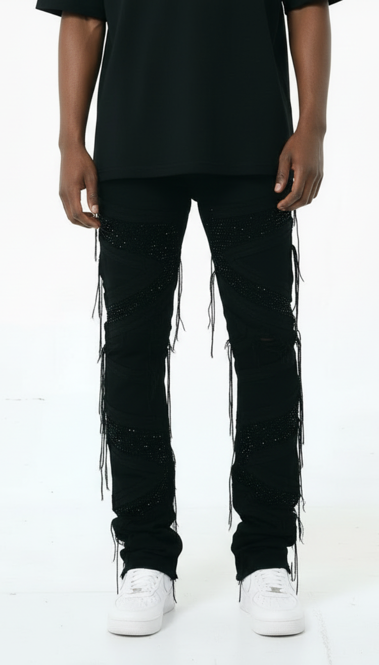 Person wearing black pants with string details on a white background