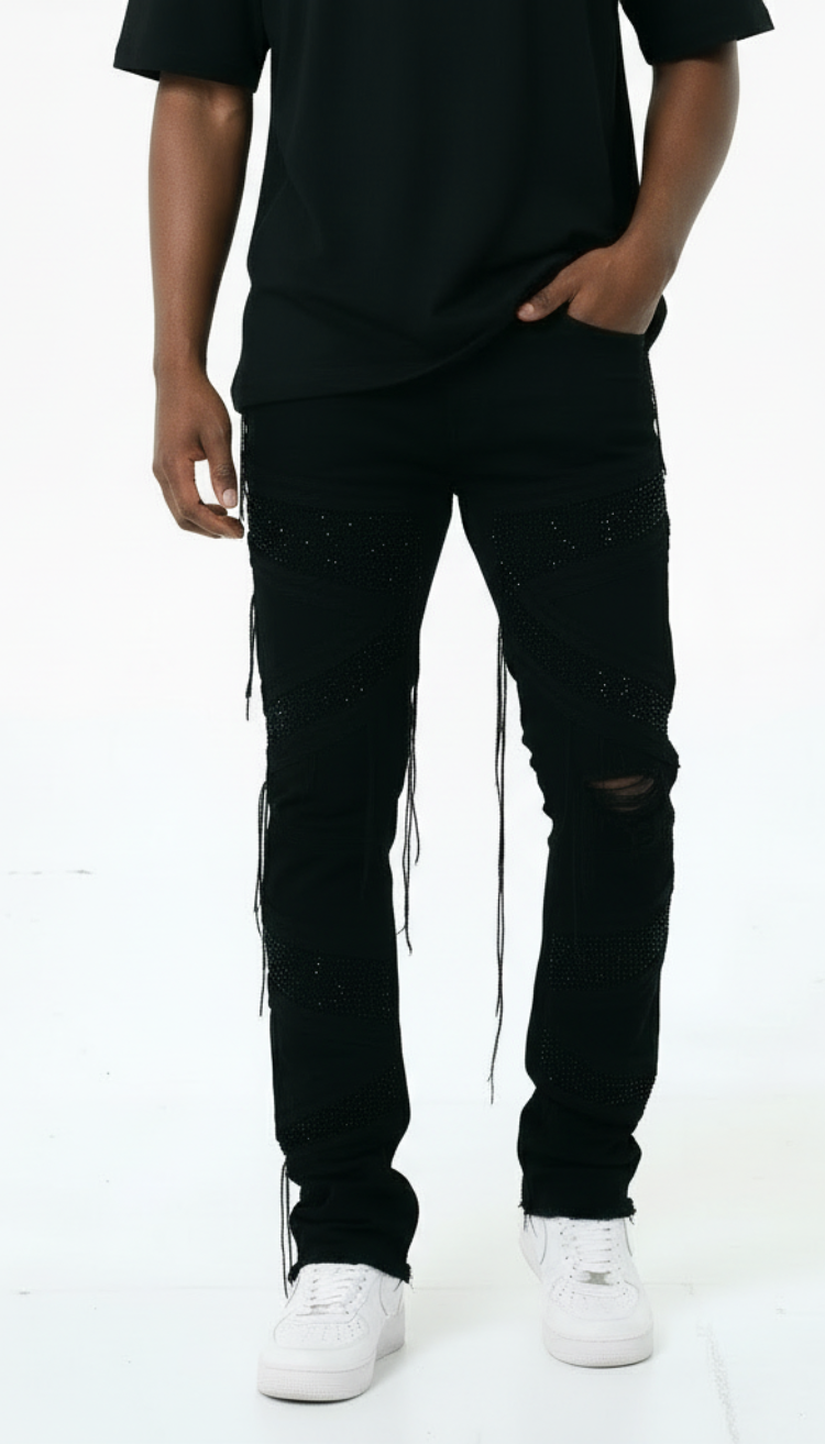 Person wearing black distressed jeans and a black t-shirt on a white background