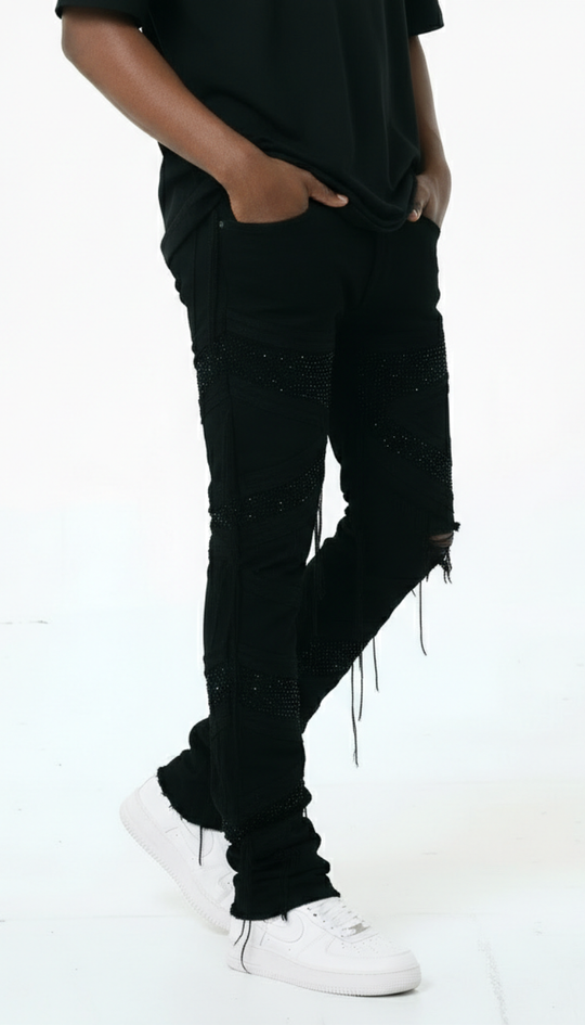 Person wearing black distressed jeans and white sneakers on a white background