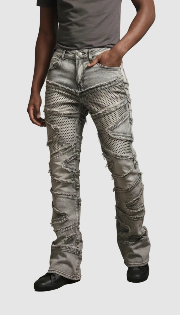 Person wearing light gray distressed jeans with a plain background