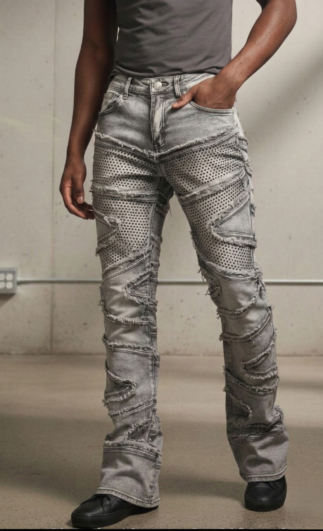Person wearing distressed gray jeans with a plain background