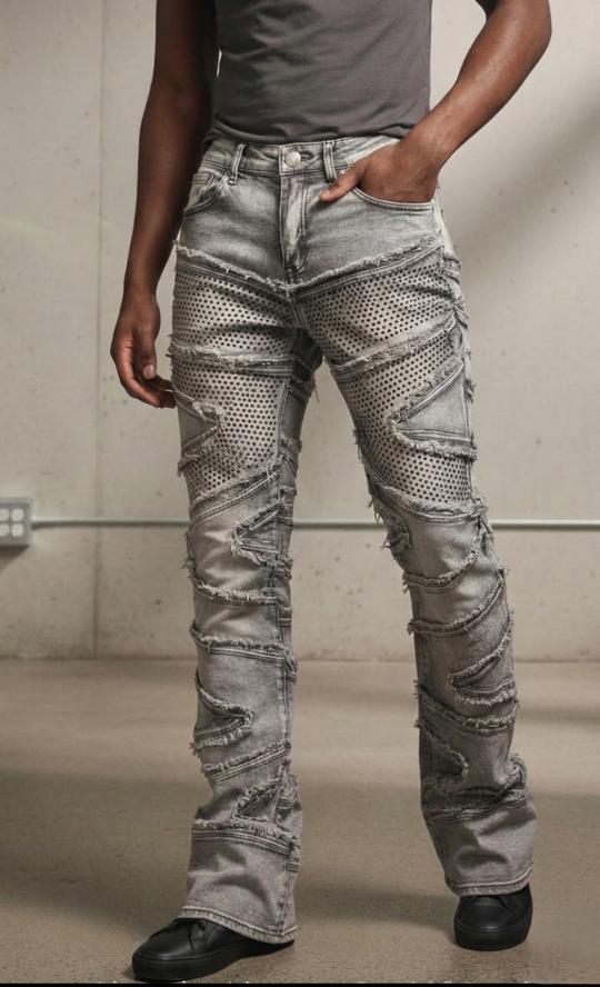 Person wearing distressed gray jeans with a plain background