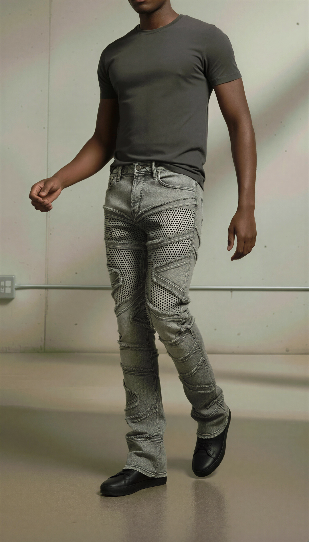 Person wearing a gray t-shirt and light gray jeans against a neutral background