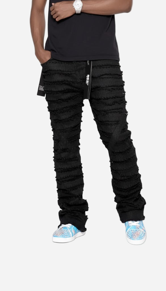 Person wearing black distressed jeans and blue sneakers on a white background