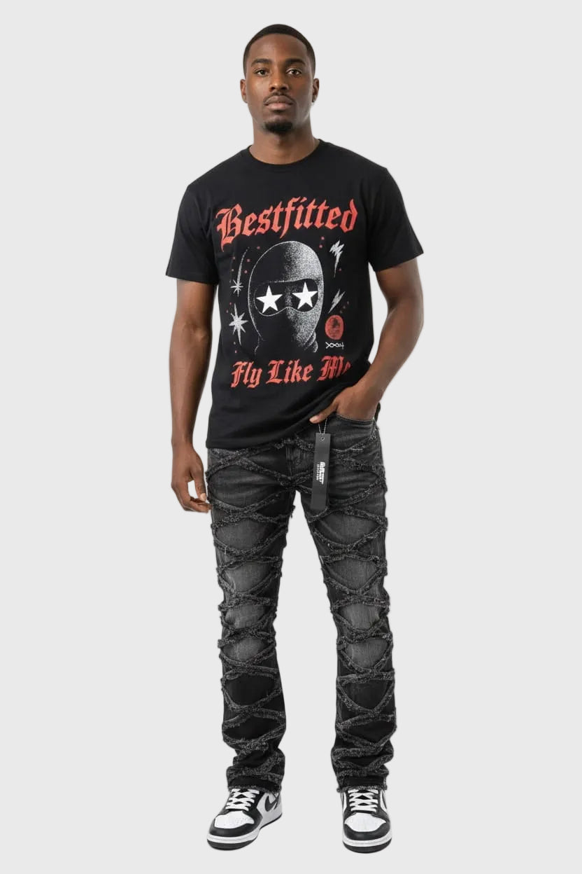 Man wearing a black t-shirt with graphic design and text, paired with distressed jeans on a white background