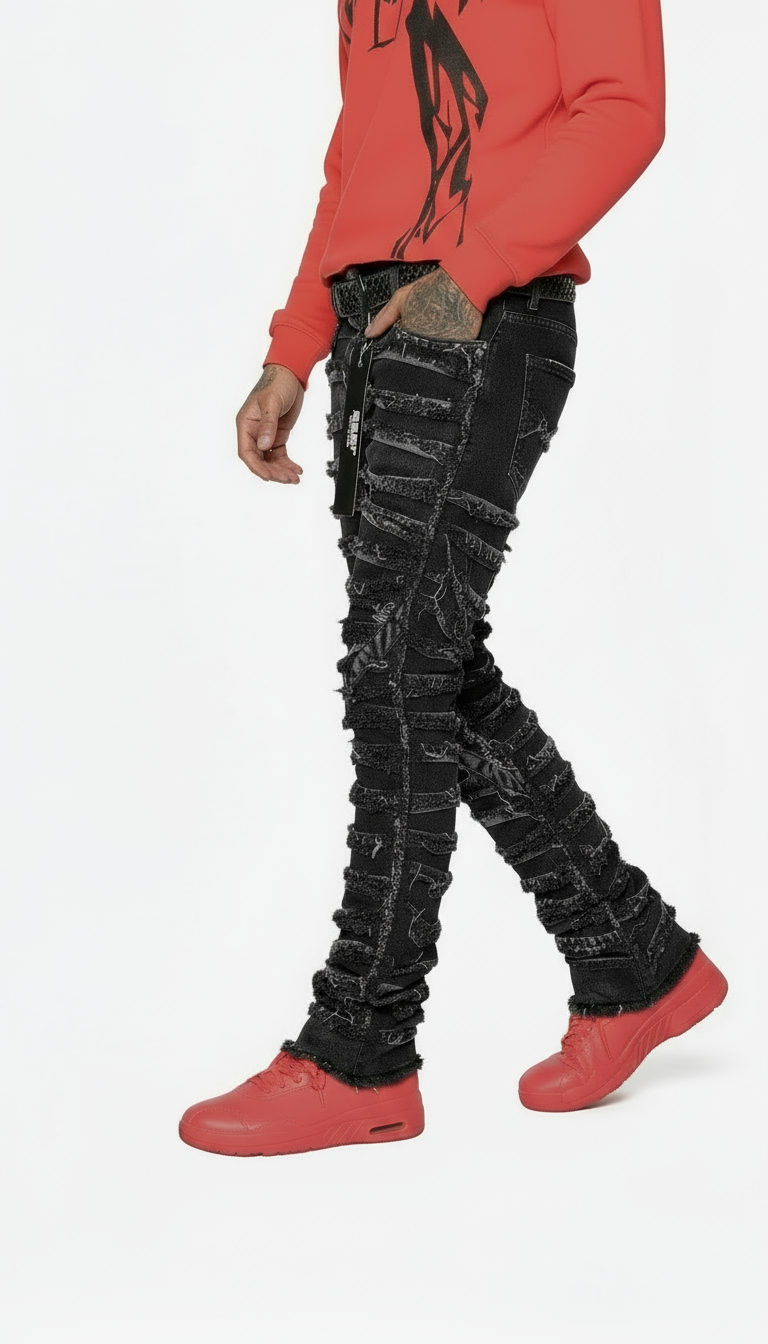 Person wearing a red hoodie and black distressed jeans on a white background