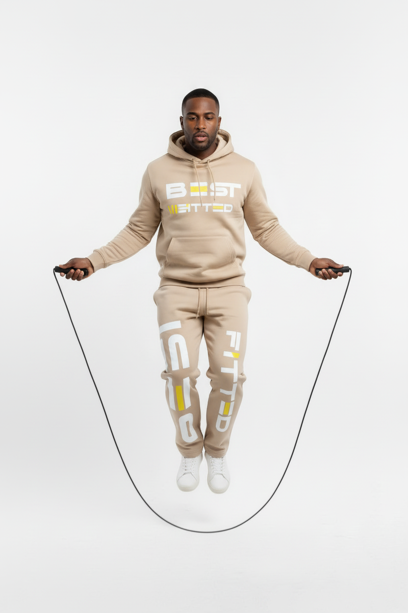 Man in a beige 'Beast Mode' tracksuit jumping rope on a white background