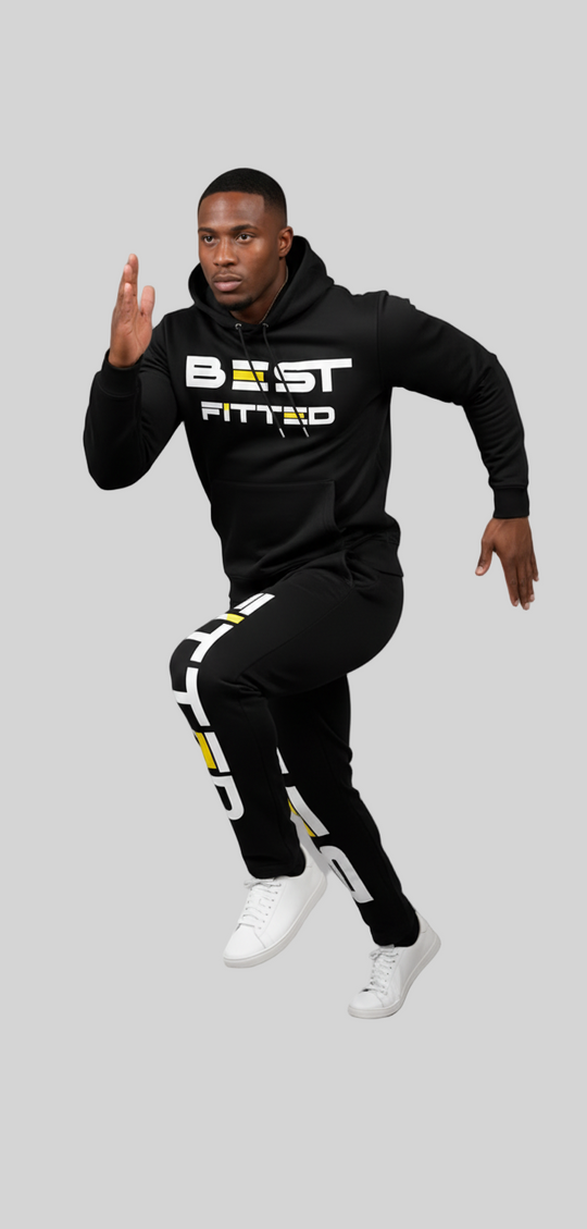 Person wearing a black 'BEAST FITTED' hoodie and pants on a gray background
