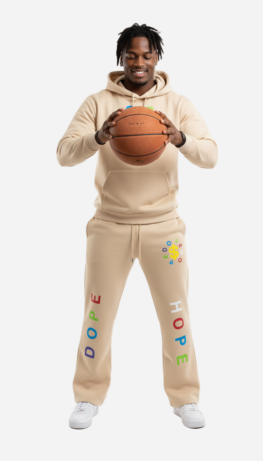 Person wearing a beige tracksuit with colorful text holding a basketball on a white background