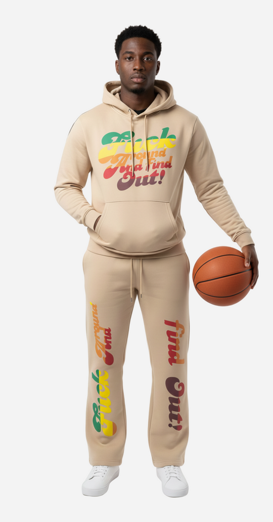 Person wearing a beige hoodie and pants with colorful text, holding a basketball on a white background