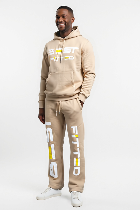 Man wearing a beige 'Fitted' tracksuit on a white background