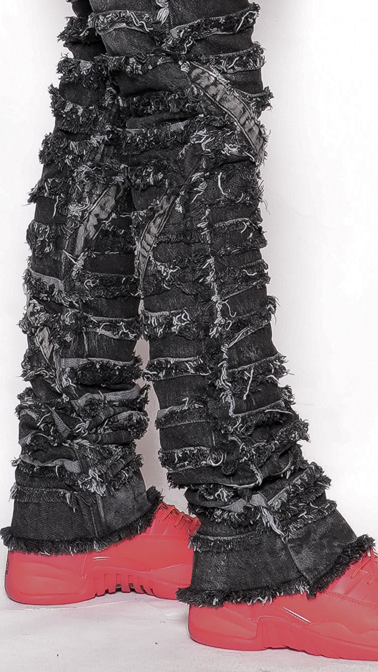 Black textured pants with red shoes on a white background